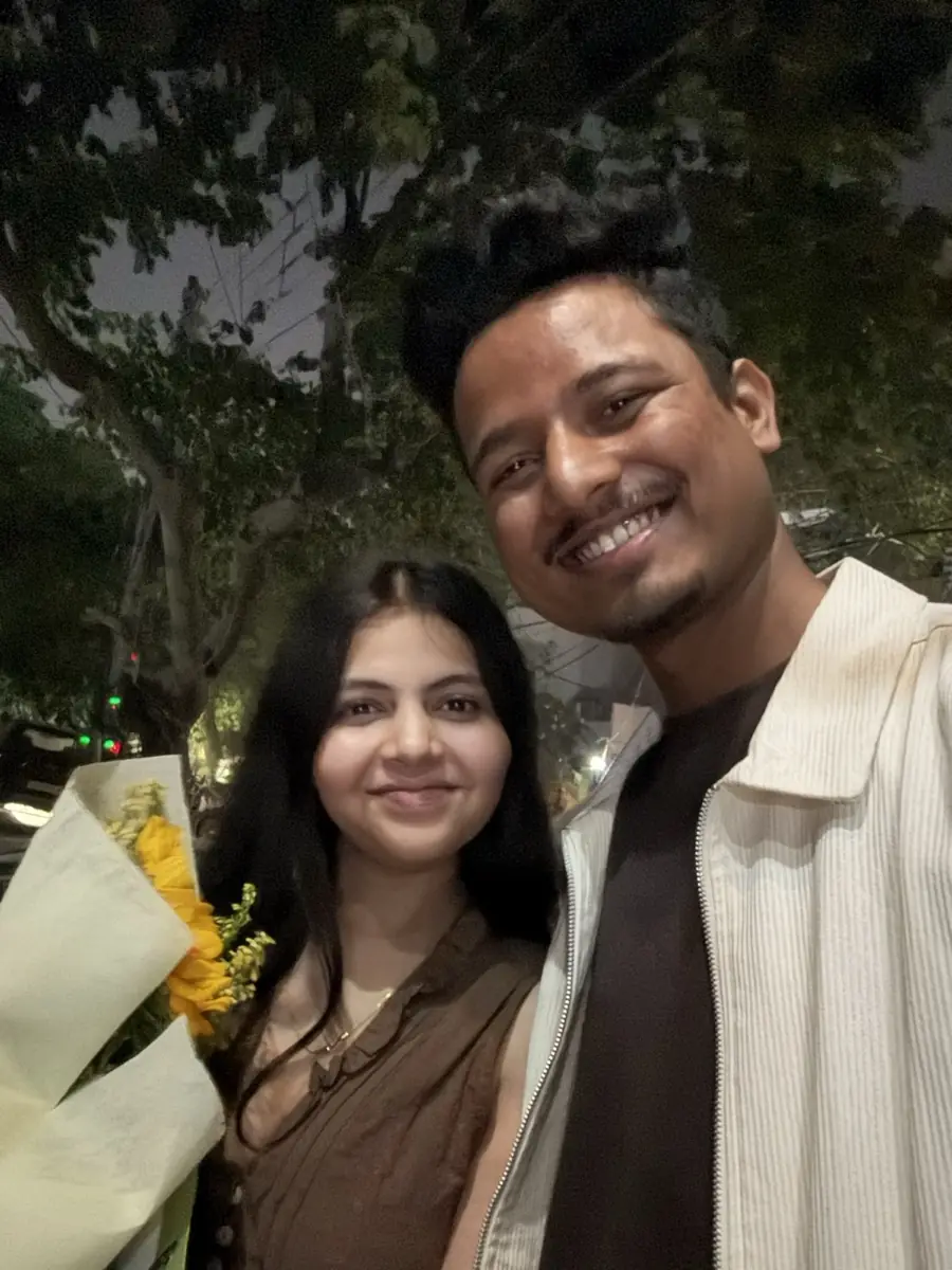 Shailesh and Bhumika at night, she holds a bouquet