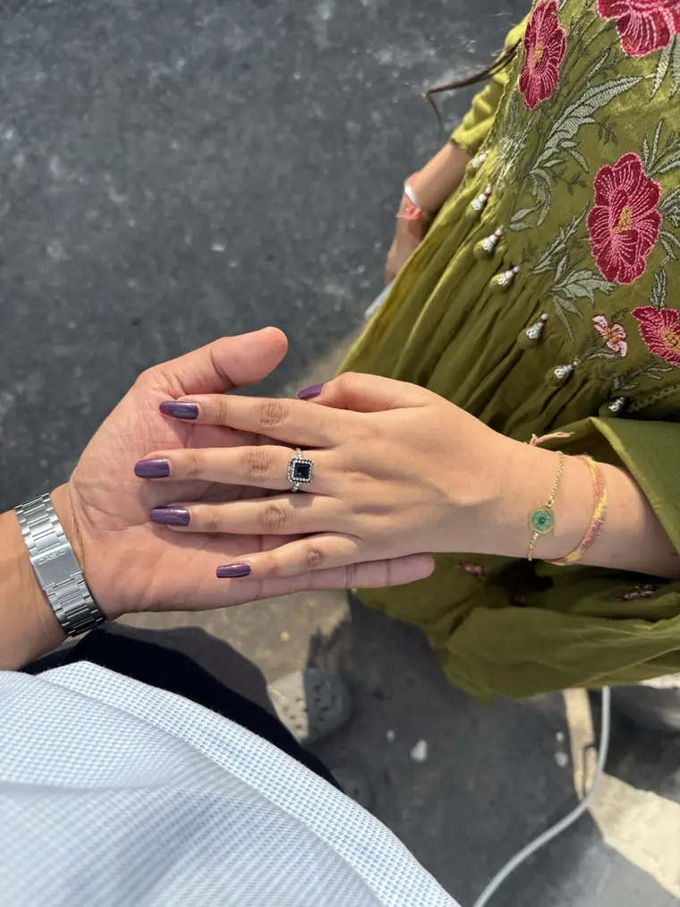 Bhumika's hand, wearing a ring, held in Shailesh's hand