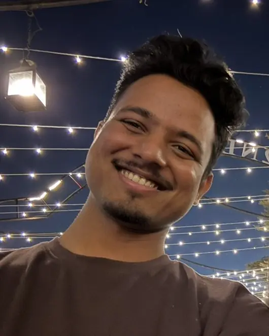 Shailesh, smiling under string lights